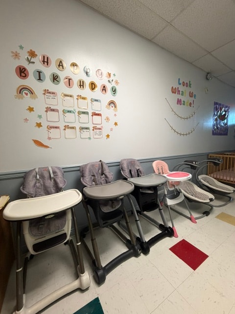 Wantagh infant room with high chairs and birthday wall